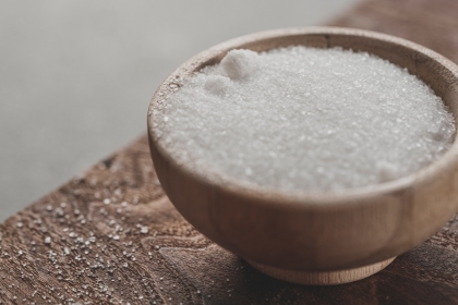 Salt in a wooden bowl on a table